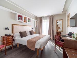 a hotel room with a bed and a desk and a desk at Hotel Central Wellness in Sorrento