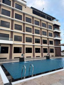 a building with a swimming pool in front of a building at Riviera Hotel and Resort in Choli
