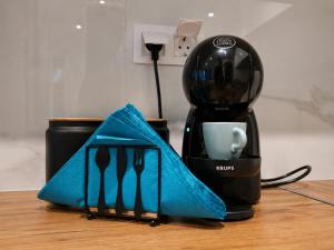 a black coffee maker with a blue napkin next to a cup at D4 Apartments Paralia No-5 in Paralia Katerinis