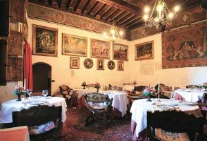 a dining room with two tables with white table cloth at Castello Di Pavone in Pavone Canavese