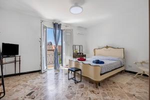 a bedroom with a bed and a tv and a balcony at The Nice Bright House in Palermo