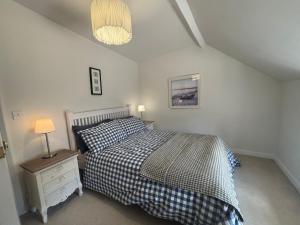 a bedroom with a bed and a lamp on a night stand at Cotford Cottage in Sidmouth