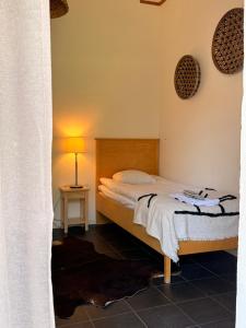 a bedroom with a bed and a lamp on a table at Wapnö Gårdshotell in Halmstad