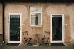 two chairs and a table in front of a building at Wapnö Gårdshotell in Halmstad