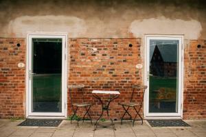 two chairs and a table against a brick wall at Wapnö Gårdshotell in Halmstad +9 photos