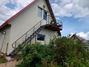 a white building with a balcony with flowers on it at Ezermala in Dagda