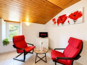 two red chairs and a table in a room at Le Cornas in Vérin