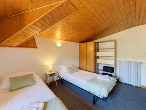 a bedroom with two beds and a wooden ceiling at Le Cornas in Vérin