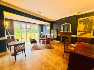 a living room with a piano and a table and chairs at Wrexham Llyndir Hotel by Belvilla in Rossett