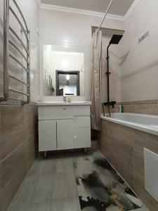 a bathroom with a sink and a tub and a mirror at Urban in Bishkek