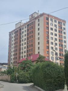 a large brick building in front of a building at Urban in Bishkek