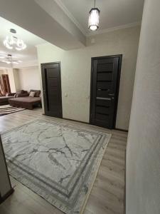 a living room with two doors and a rug at Urban in Bishkek