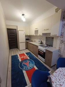 a kitchen with a blue chair and a white refrigerator at Urban in Bishkek +1 photo