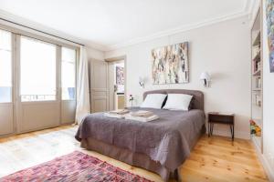 1 dormitorio con cama y ventana grande en 1 Square du Docteur Blanche - Paris 16 en París