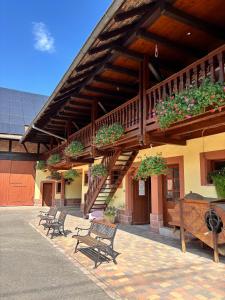 a building with benches and potted plants on it at Chambres d'hôtes chez Adam 
