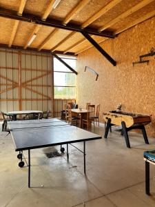 a room with two ping pong tables and chairs at Chambres d'hôtes chez Adam 