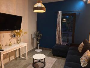 a living room with a couch and a tv at House - Maison Blue Print- 2 bedrooms in Surinam