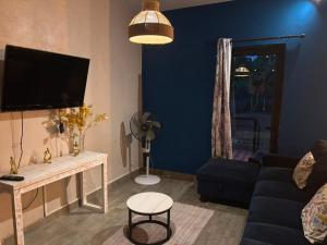 a living room with a couch and a tv at House - Maison Blue Print- 2 bedrooms in Surinam