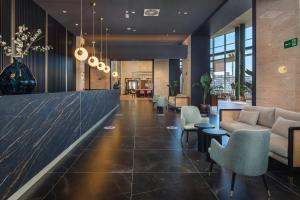 a lobby with a couch and chairs in a building at Meliá Valencia in Valencia +92 photos