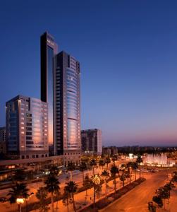 a city with tall buildings and palm trees at night at Meliá Valencia in Valencia