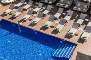 an overhead view of a swimming pool with lounge chairs and a swimming pool at Meliá Valencia in Valencia