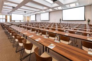 an empty lecture hall with long tables and chairs at Meliá Valencia in Valencia