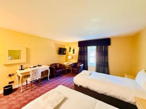 a hotel room with two beds and a desk at Wrexham Llyndir Hotel by Belvilla in Rossett