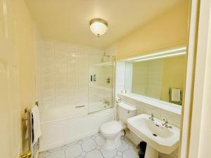 a white bathroom with a sink and a toilet and a tub at Wrexham Llyndir Hotel by Belvilla in Rossett +74 photos
