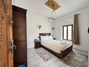 a bedroom with a bed and a wooden door at Riad Ba brahim in Rabat