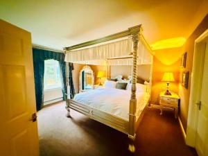 a bedroom with a canopy bed in a yellow room at Wrexham Llyndir Hotel by Belvilla in Rossett