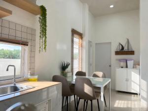 a kitchen with a sink and a table with chairs at เอกสิริ รีสอร์ต in Amphoe Tha Chana