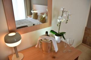 a table with a lamp and glasses and a mirror at Villaggio Artemide in Giardini Naxos