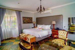 a bedroom with a large white bed and a chair at Kasimba Boutique Hotel in Gaborone +40 photos
