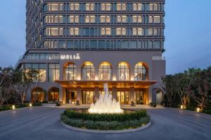 a hotel with a fountain in front of a building at Meliá Pattaya Hotel in Pattaya