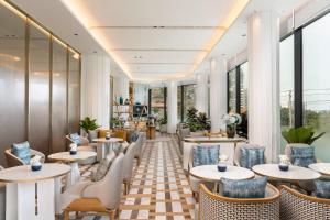 a restaurant with tables and chairs and windows at Meliá Pattaya Hotel in Pattaya +93 photos