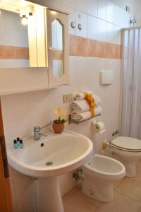 a bathroom with a sink and a toilet and a mirror at Villaggio Artemide in Giardini Naxos +83 photos