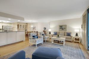 a living room with couches and a kitchen at Compass Point 221 in Sanibel