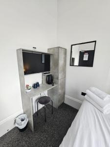 a hotel room with a desk and a bed at Edinburgh City Hotel in Edinburgh