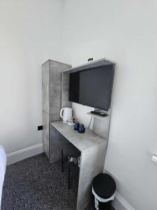a room with a desk with a tv on a wall at Edinburgh City Hotel in Edinburgh +24 photos