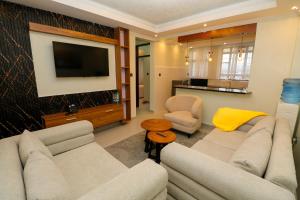 a living room with two couches and a television at Maraluxe Resoert & Spa in Nakuru +7 photos