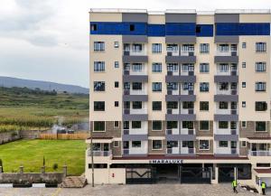 a tall apartment building with a lawn in front of it at Maraluxe Resoert & Spa in Nakuru