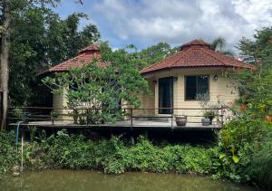 a small house on a dock next to a river at Navari Homestay in Rayong +40 photos