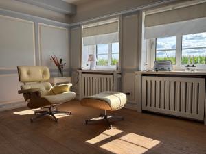 a living room with two chairs and a table at Deichhof Whg Luana in Dunsum
