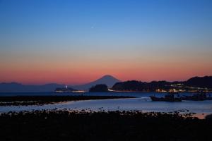 a sunset over the water with a mountain in the background at 海と富士山を望む4名1棟貸し古民家宿 最大7名 鎌倉エリアの隠れ家 in Zushi
