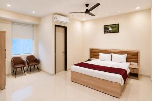 a bedroom with a bed and a table and chairs at Hotel 33 Inn in Kānpur +18 photos