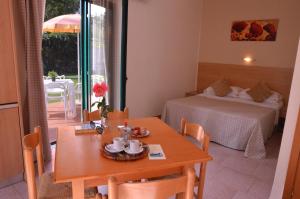 a room with a table and a bed and a table and chairs at Villaggio Artemide in Giardini Naxos