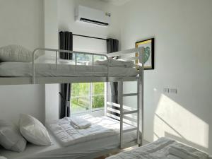 two bunk beds in a room with a window at เอกสิริ รีสอร์ต in Amphoe Tha Chana