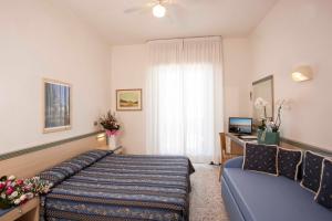 カットーリカにあるHotel Brigのベッドとソファ付きのホテルルーム