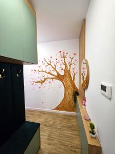 a kitchen with a tree mural on the wall at Sakura Residence Felix in Sînmartin