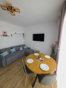 a table and chairs in a living room with a couch at Sakura Residence Felix in Sînmartin